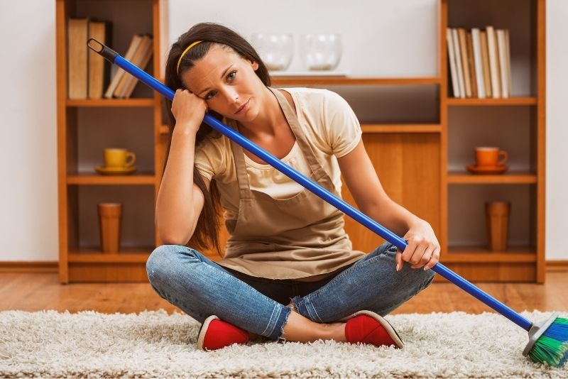 a girl cleaner sitting and holding a cleaning mop