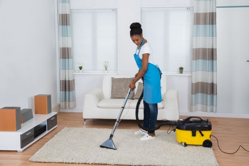 cleaning a carpet on the floor using a vacuum