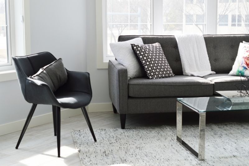 Spotless living room with a grey sofa, armchair and glass coffee table