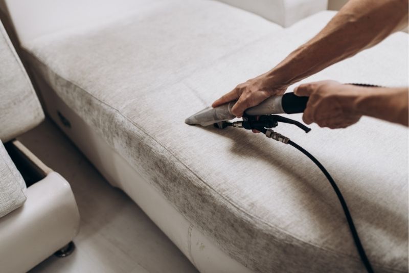 Steam cleaning a couch cushion during a deep clean in Cairns Central