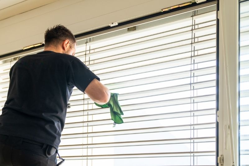 Cleaner vacuuming a lounge room carpet during an end of lease clean