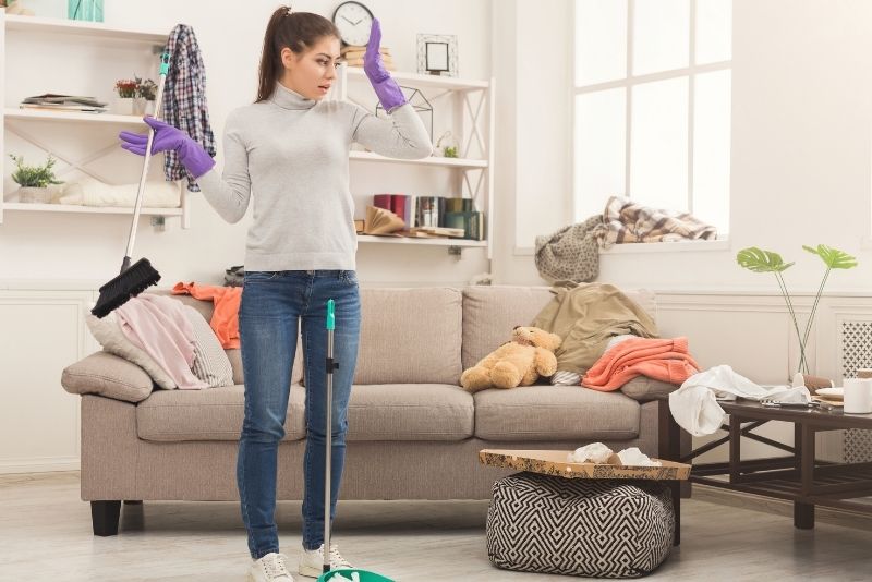 Cleaner assessing a cluttered lounge room before a house clean in Cairns Central