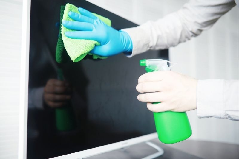 Wiping down a TV screen during a one-off clean in Cairns Central